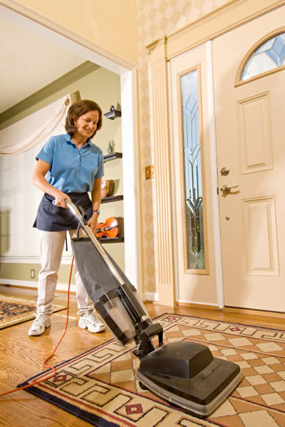 Nettoyage résidentiel: femme de ménage passe l'aspirateur